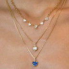 Five clear stone station necklaces layered on a model