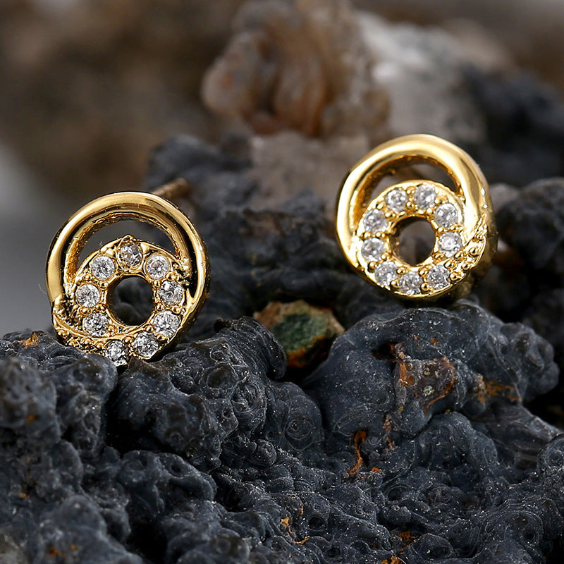 gold plated spiral halo zirconia stud earrings on dark stone