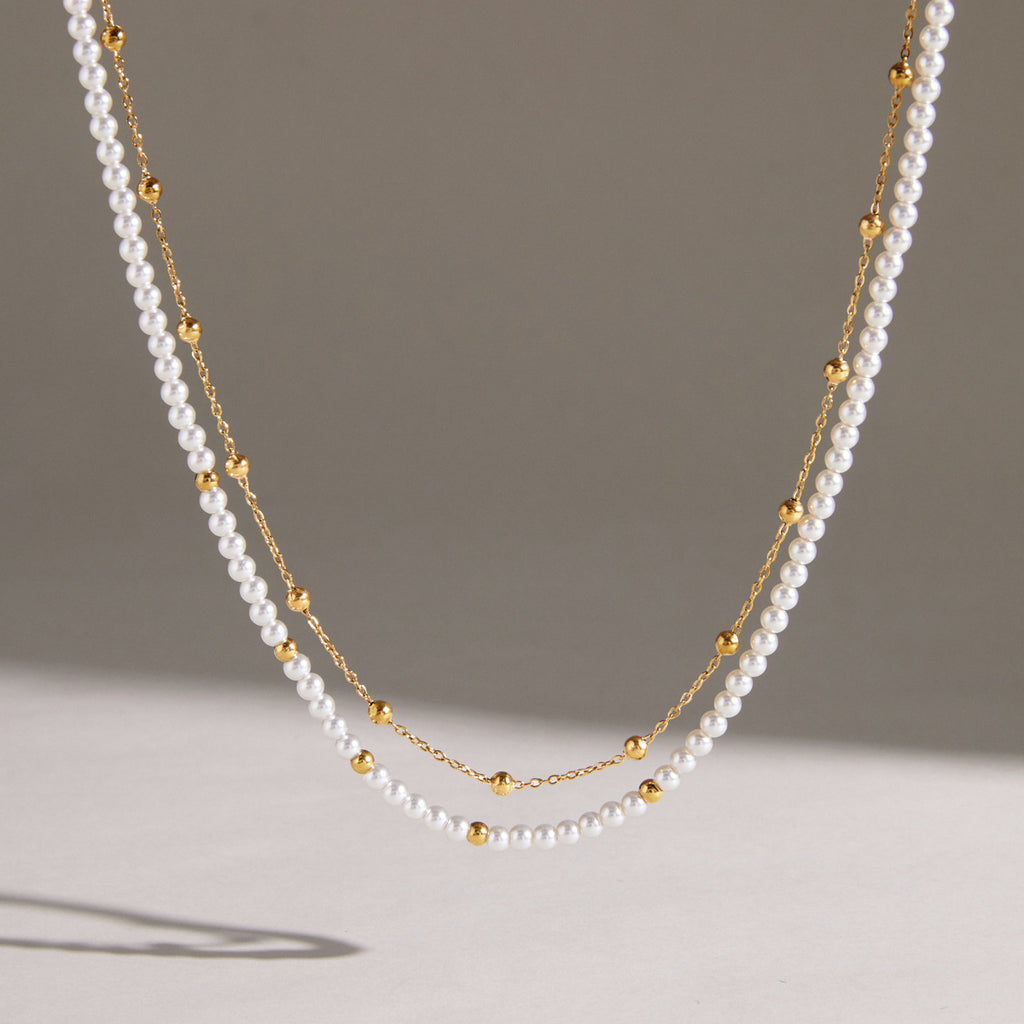 Acrylic pearl and gold-tone chain strands hanging together