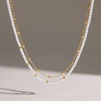 Acrylic pearl and gold-tone chain strands hanging together