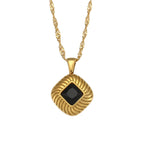 isolated gold plated square pendant necklace with a black stone