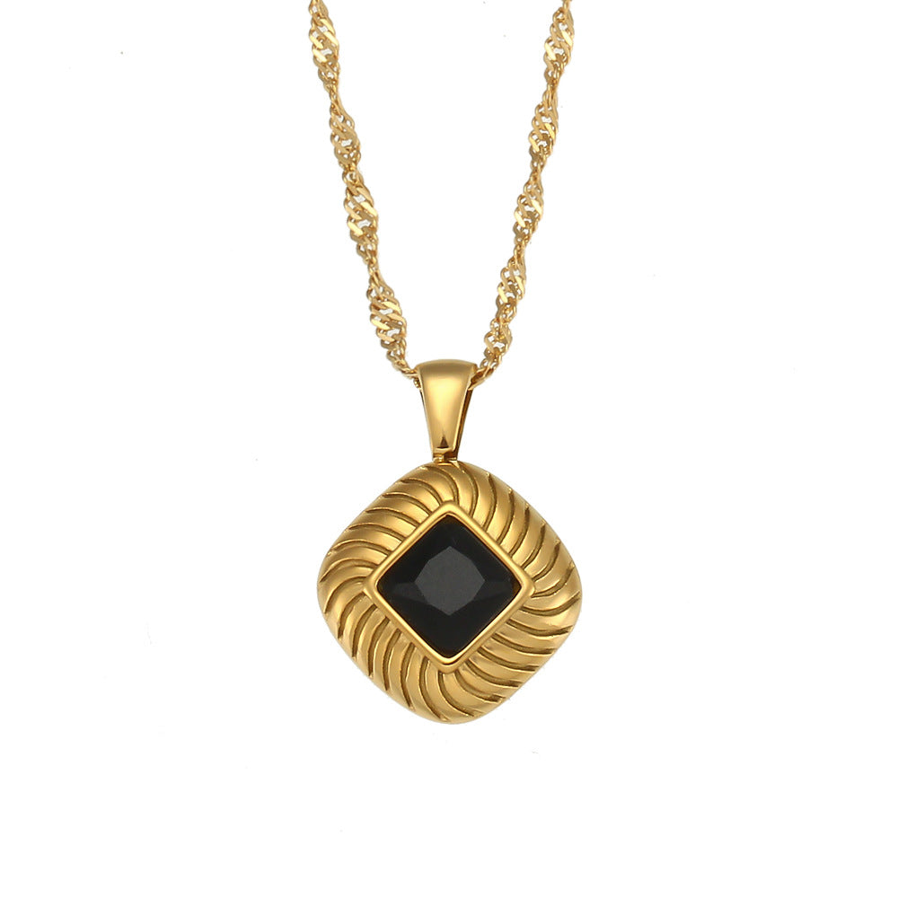isolated gold plated square pendant necklace with a black stone