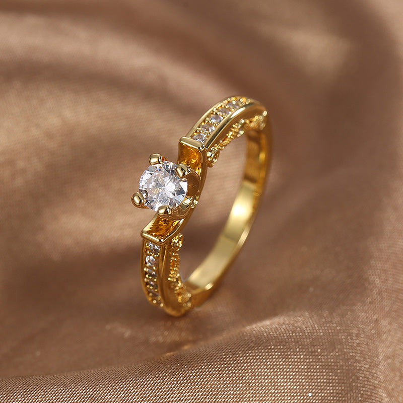 upright view of a round clear stone ring with shoulder accents