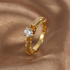 upright view of a round clear stone ring with shoulder accents