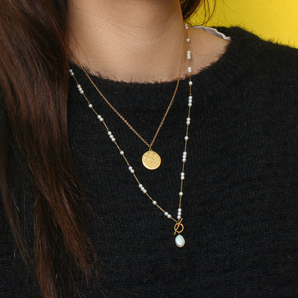 model layering the long pearl-style toggle necklace with a shorter chain