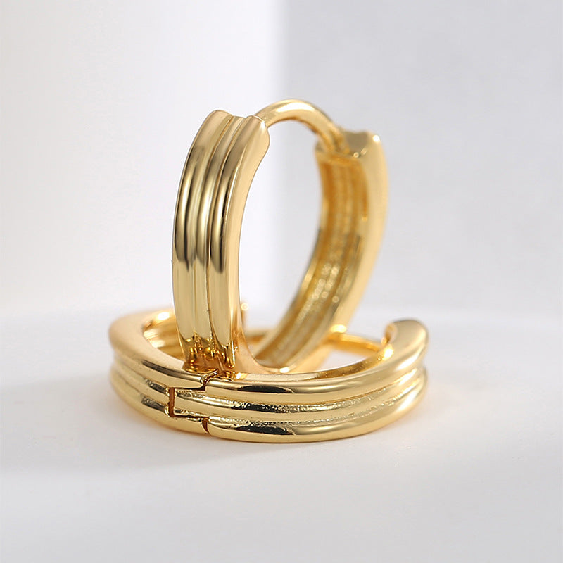 close-up of gold plated triple-ridge huggie hoop earrings