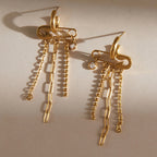 Pair of safety pin motif earrings laid flat