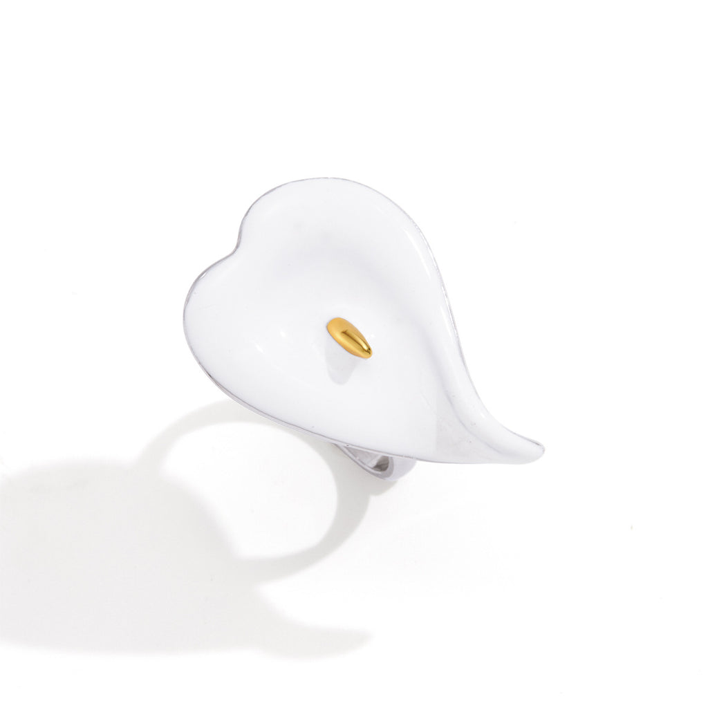 Front view showing curled white petal and gold tone center