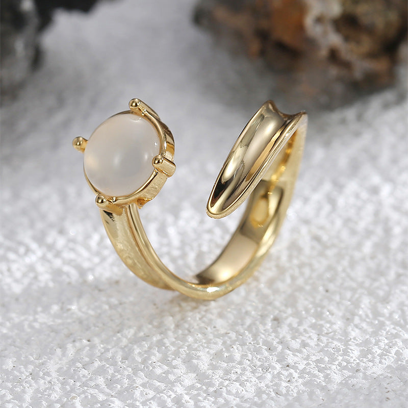 angled open-front ring showing milky cabochon and curved band