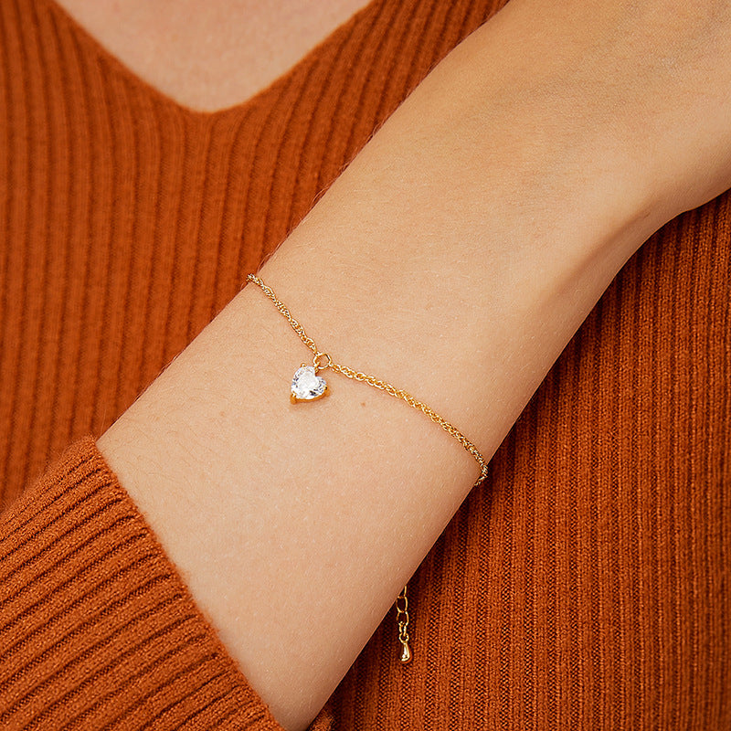 model wearing a fine chain bracelet with a faceted clear heart