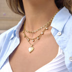 Winged heart necklace layered with separate heart-link designs