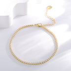 clear stone tennis anklet arranged beside a white display