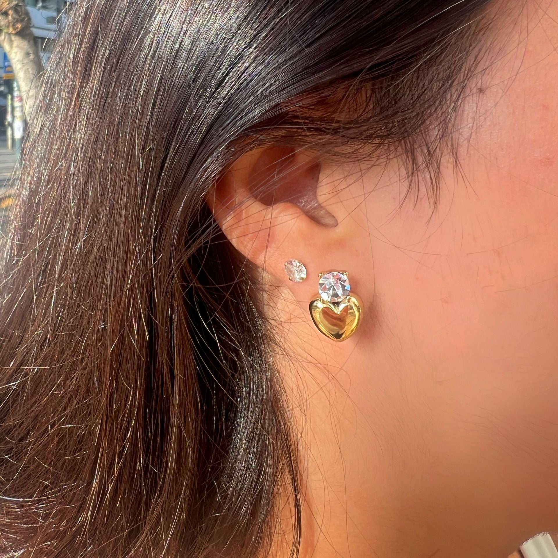 model wearing gold plated clear stone heart drop stud earrings