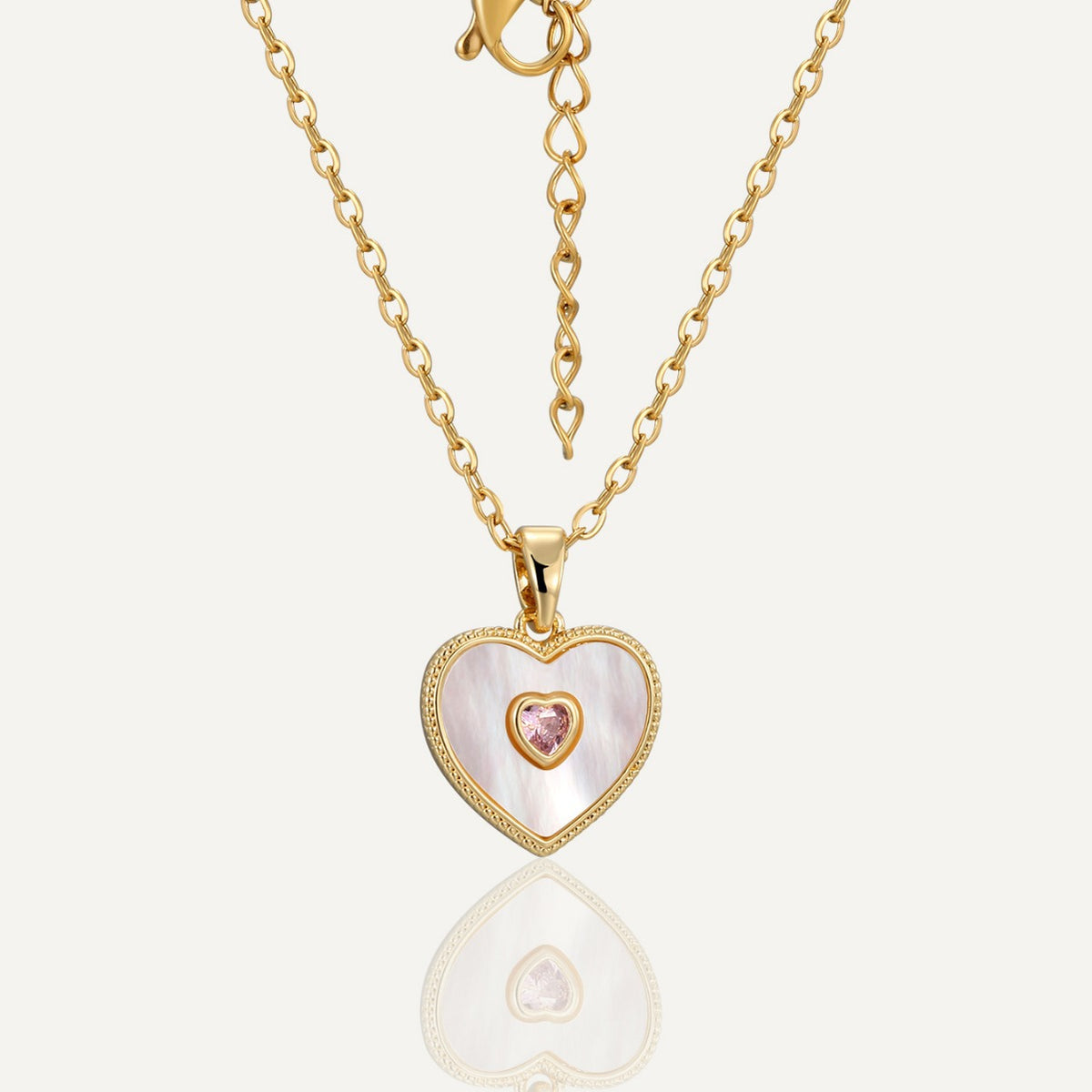 gold plated stainless steel heart necklace with iridescent white inlay and pink stone