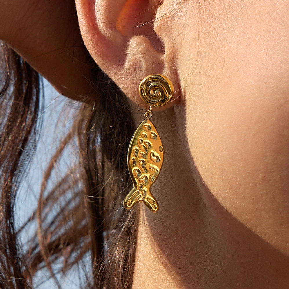 Spiral stud and dimpled fish drop worn close-up
