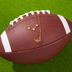 gold plated football necklace arranged on a sports ball