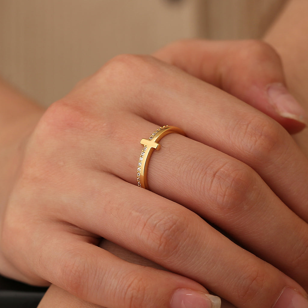 slim pavé-style cross ring worn on the middle finger