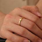 slim pavé-style cross ring worn on the middle finger