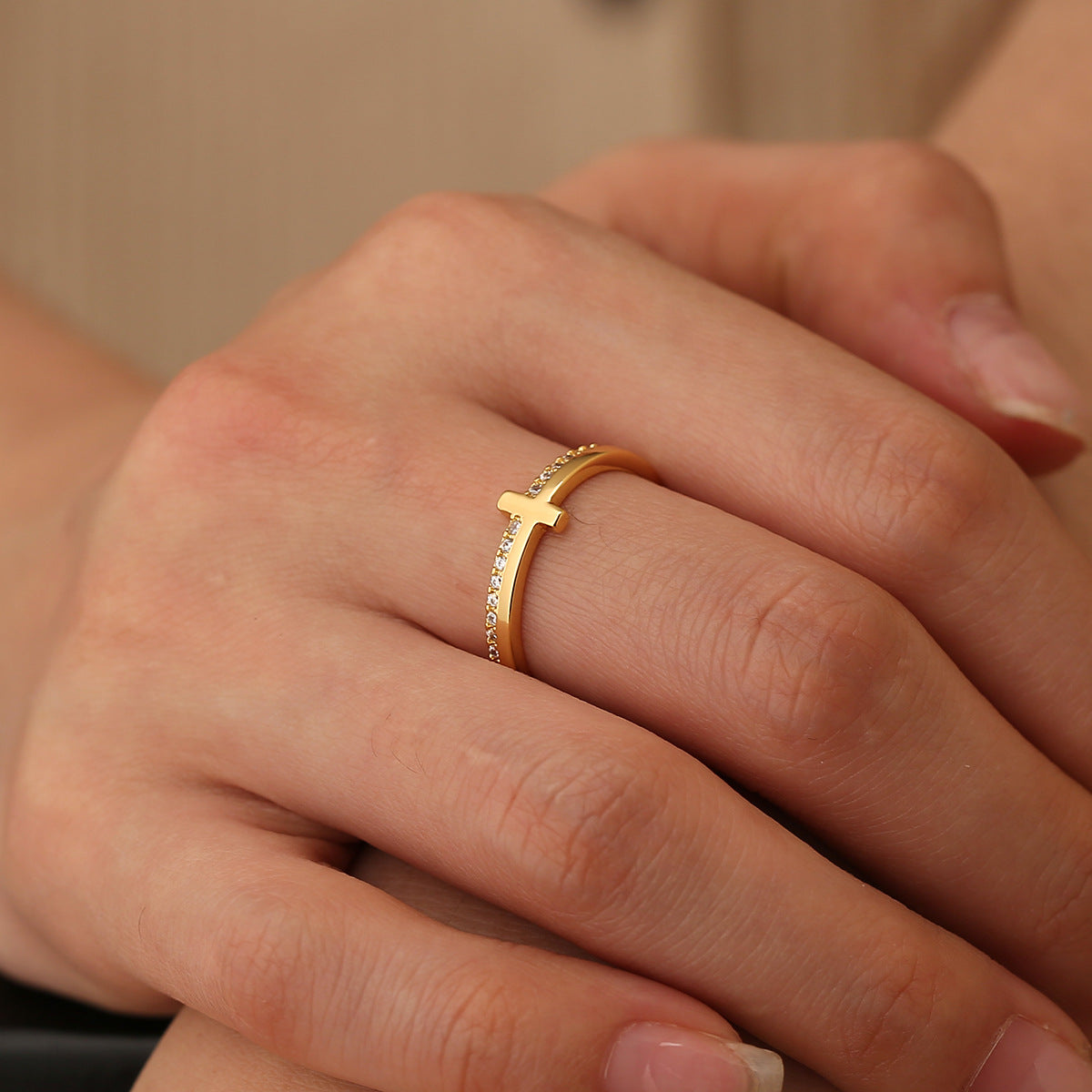 slim pavé-style cross ring worn on the middle finger