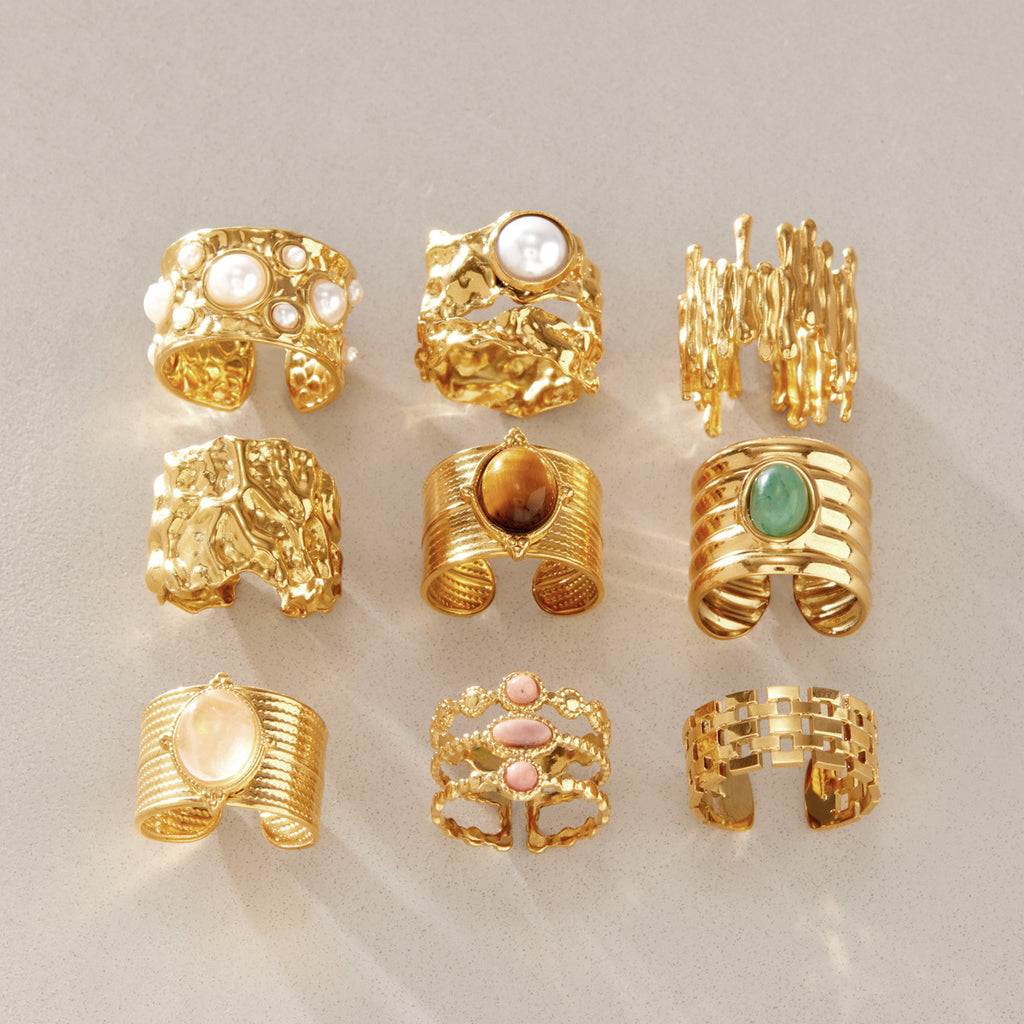Nine broad ring designs arranged on a neutral surface