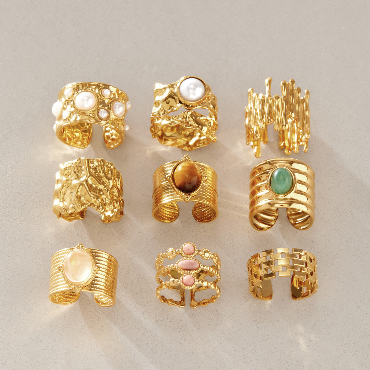 Nine broad ring designs arranged on a neutral surface