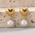 gold plated heart and white shell pearl drop earrings on stone
