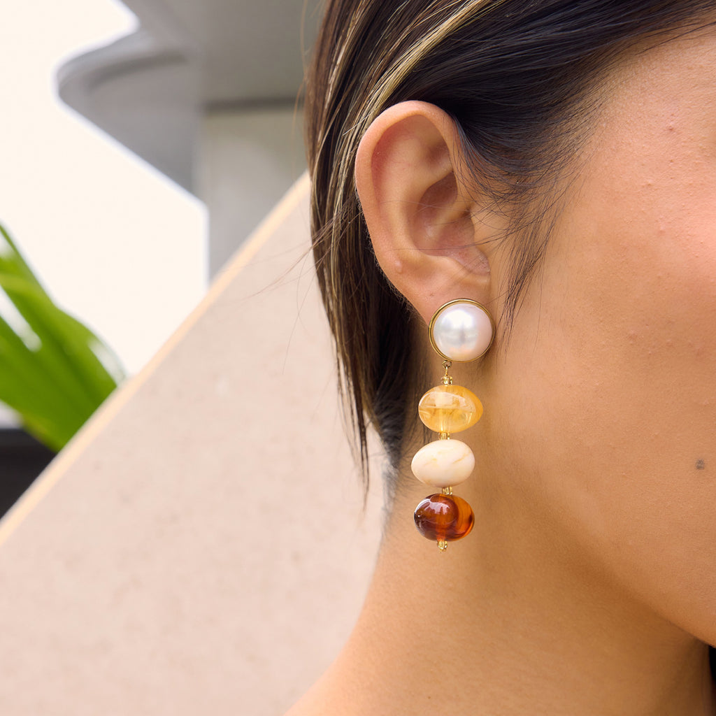 Amber cream and burgundy bead earring worn close-up