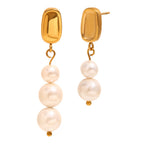 isolated pair of asymmetrical stainless steel pearl drops