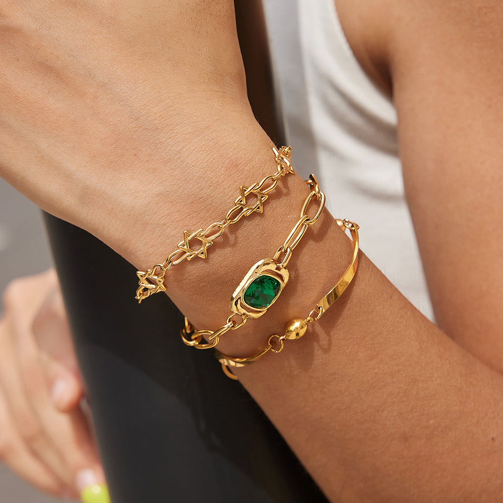 Star green-accent and curved-bar bracelets worn together