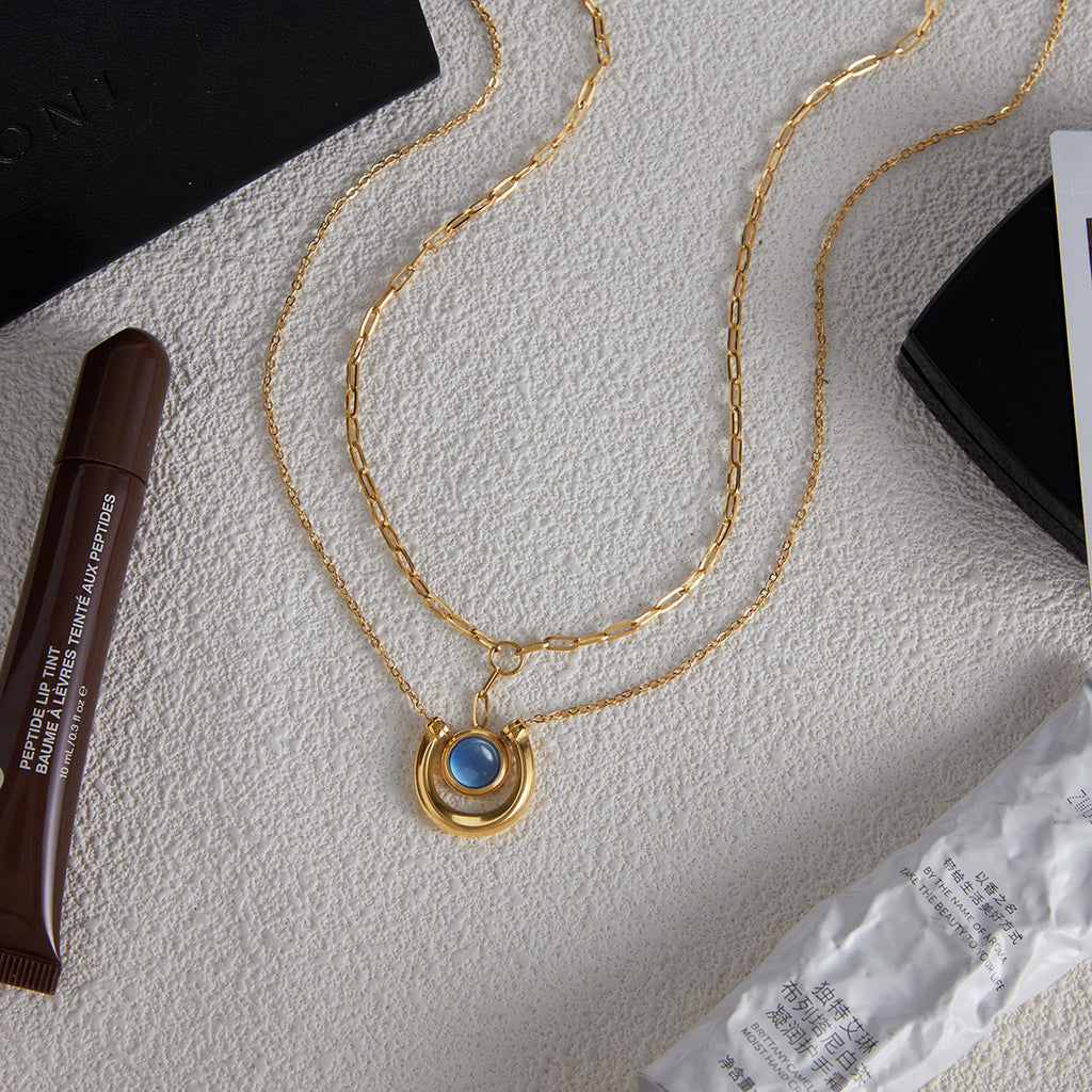 Gold Tone Blue Cabochon Stainless Steel Equestrian Necklaces — styled view of both necklace designs