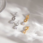 Gold- and silver-finish asymmetric drop earrings arranged on stone