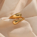 Polished gold-tone teardrop ends on pale fabric
