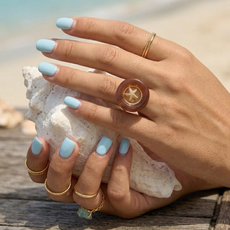 Brown acrylic starfish ring worn on hand