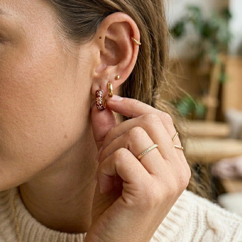 Brown floral hoop shown close-up on an ear