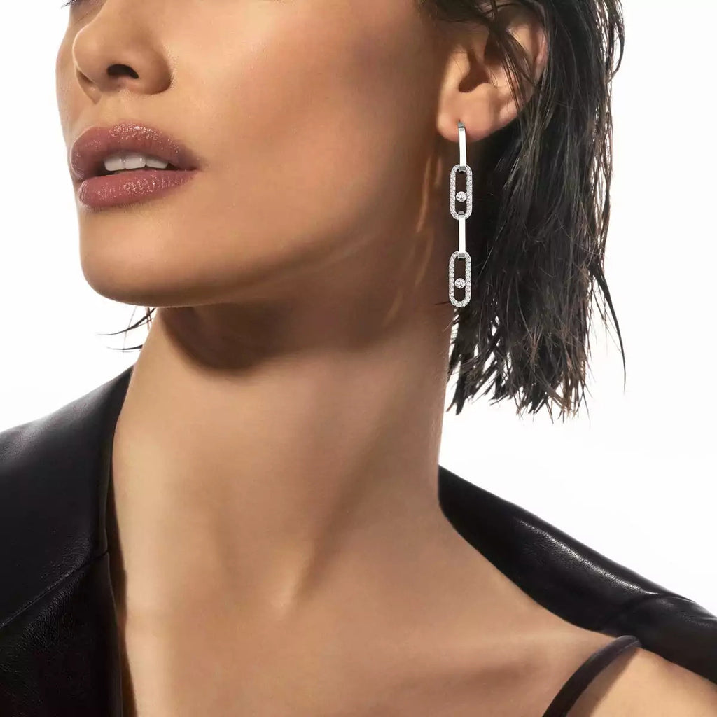 Long linked earrings worn with a black top
