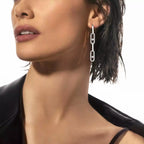 Long linked earrings worn with a black top