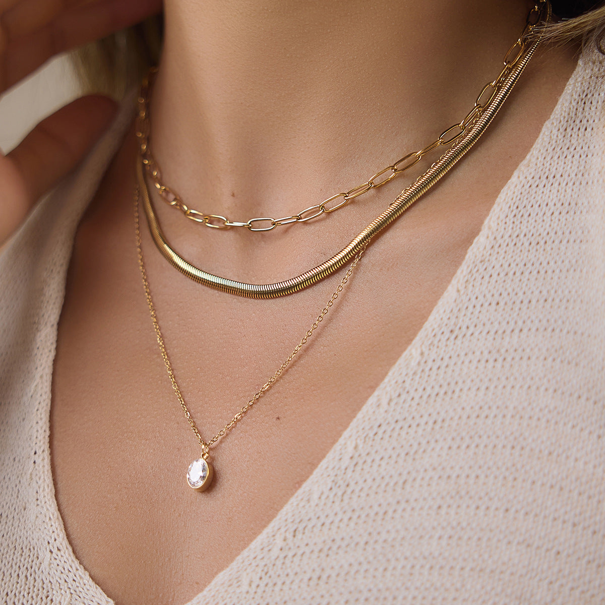 Close-up of three chain textures and oval clear pendant