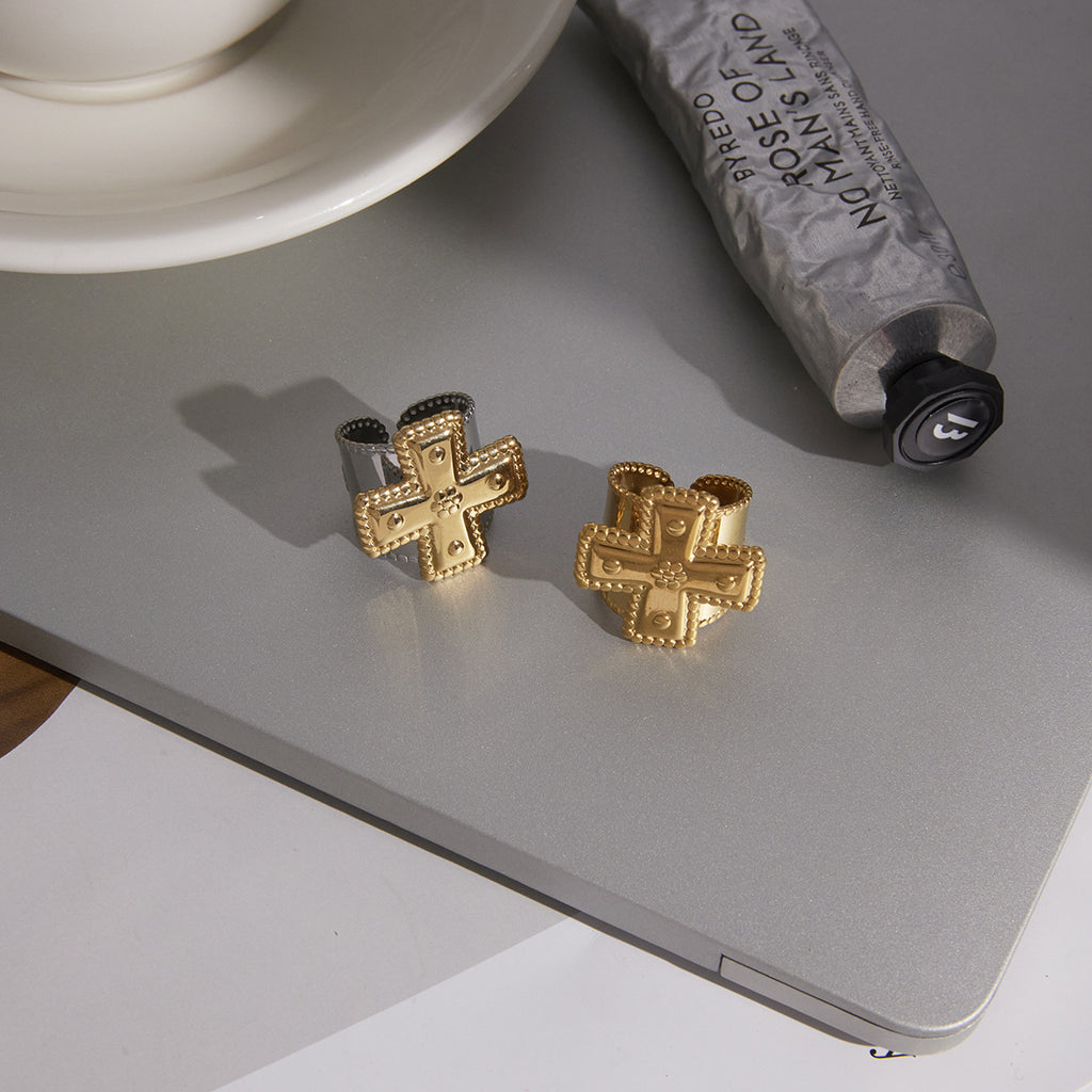gold plated and two-tone cross rings on a gray styling surface