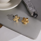 gold plated and two-tone cross rings on a gray styling surface