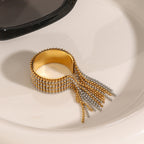 Two-tone beaded fringe ring resting beside sunglasses