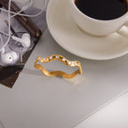 Wavy clear-stone bangle beside a cup