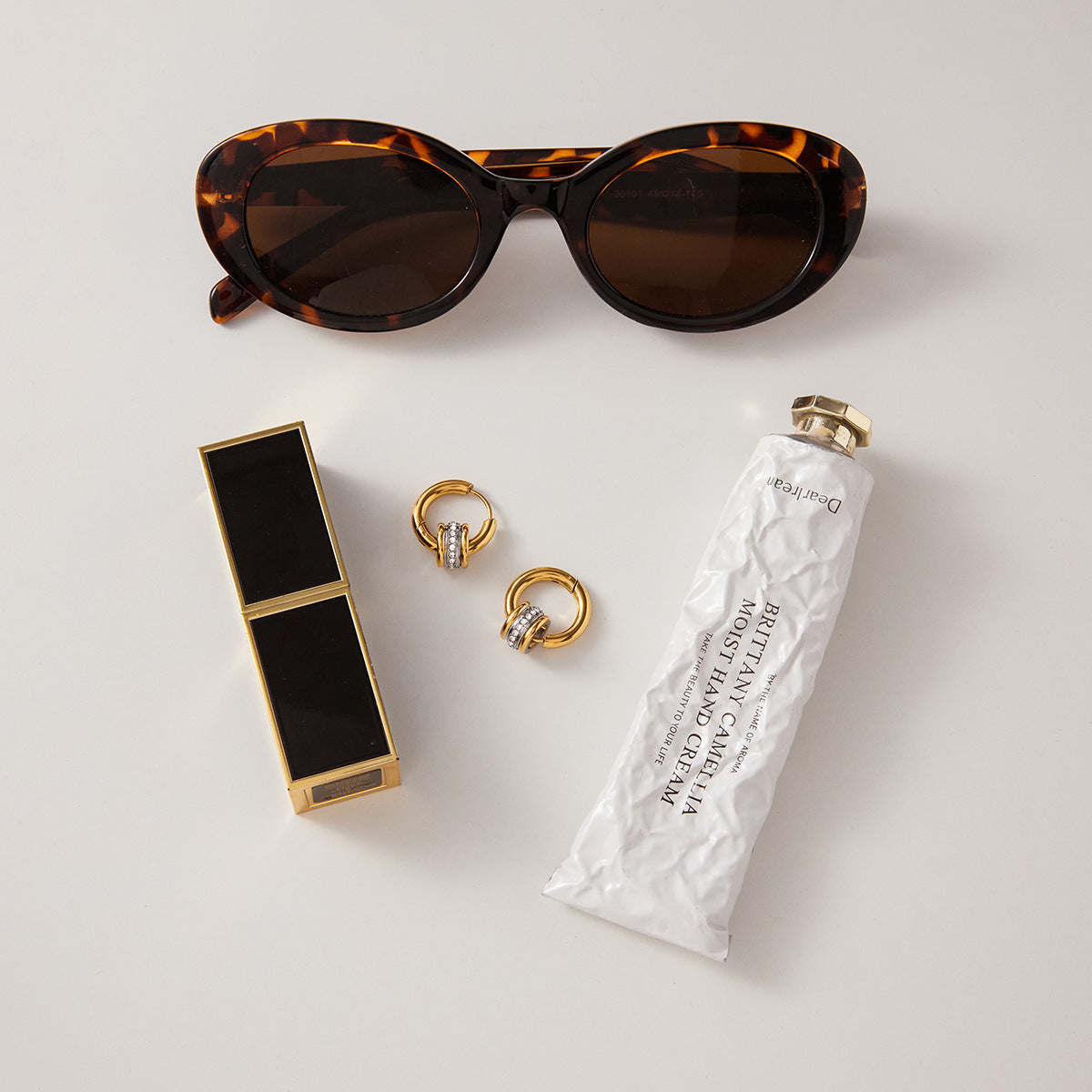 Styled view of interlocking gold and silver-color hoop earrings