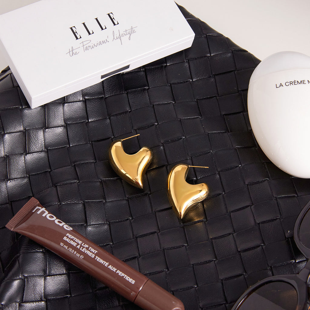 Asymmetric heart and elongated oval stud earrings styled flat lay
