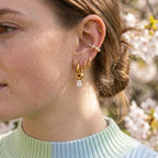Clear rectangular stone drop hoop worn with other earrings
