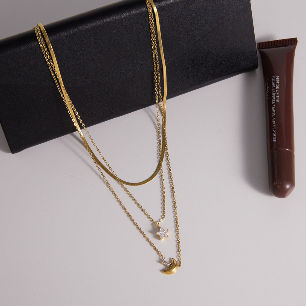 Triple chain necklace displayed on a black accessory
