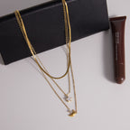 Triple chain necklace displayed on a black accessory