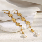 textured gold plated pearl earrings arranged on white fabric