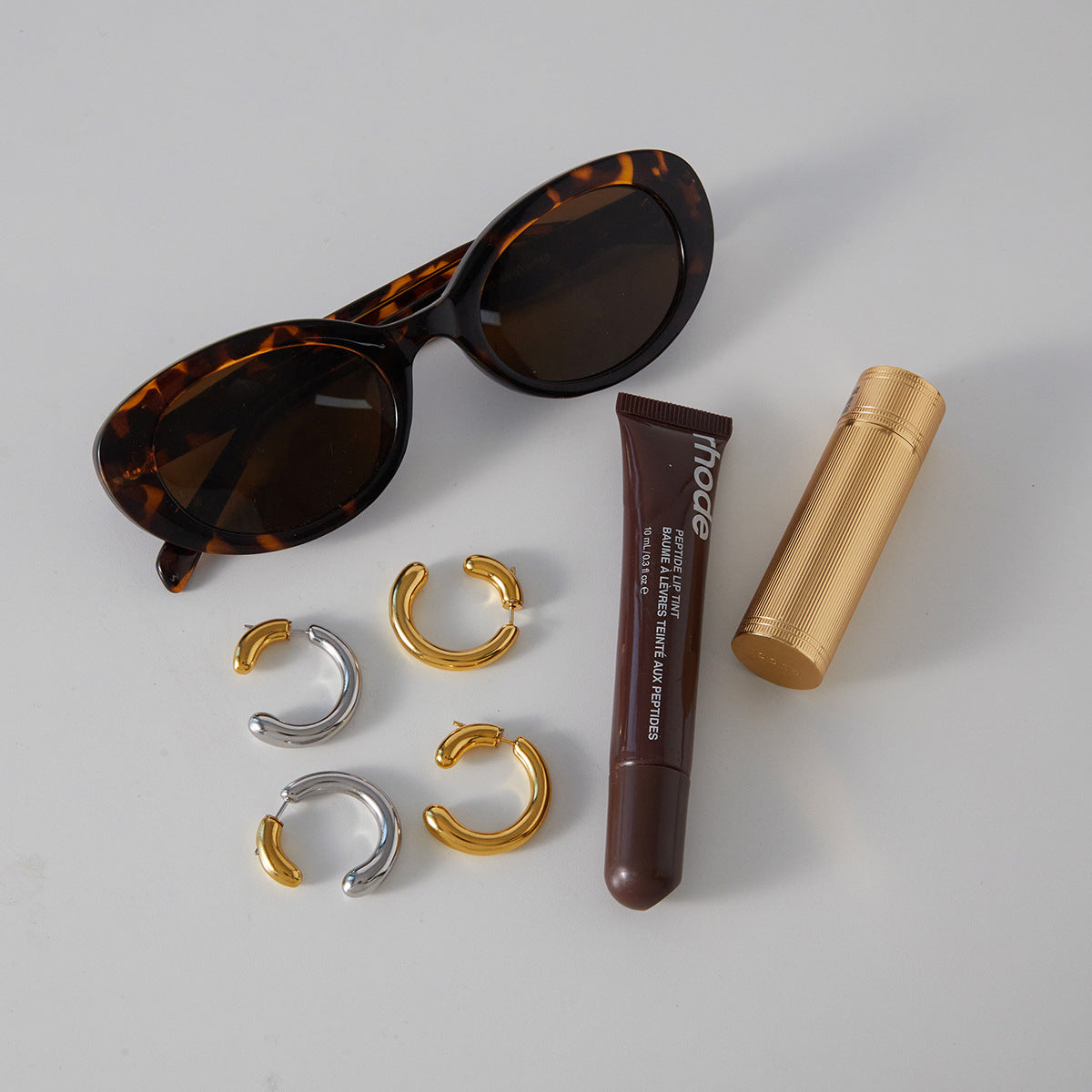 gold plated and two-tone stainless steel open hoop earrings styled with sunglasses