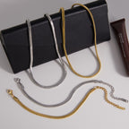 Gold and silver tone snake chain necklaces and bracelets displayed together