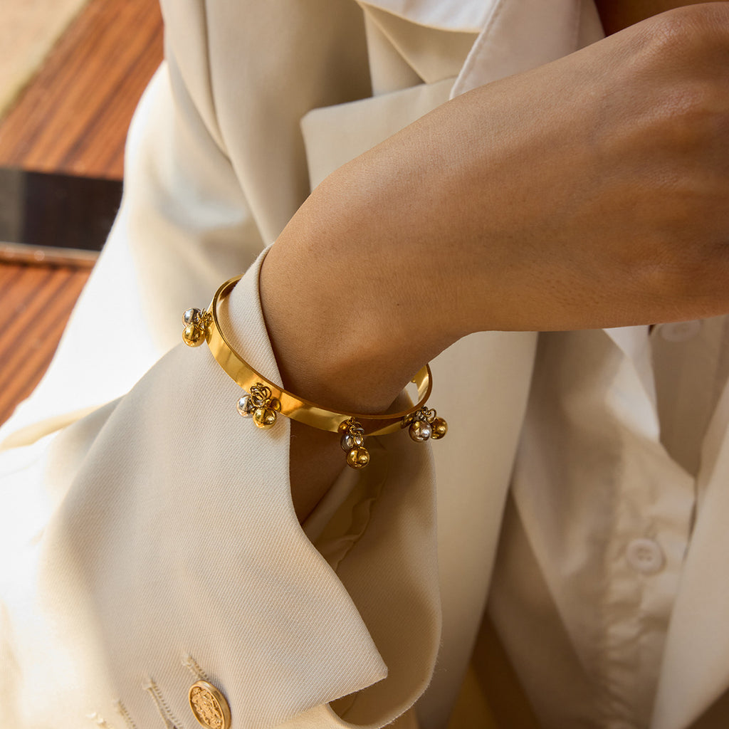 Two-tone ball fringe open cuff worn on a wrist